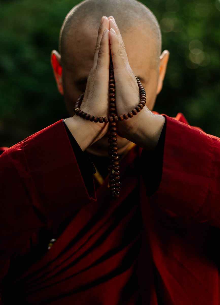 man in red suit wearing gold beaded necklace