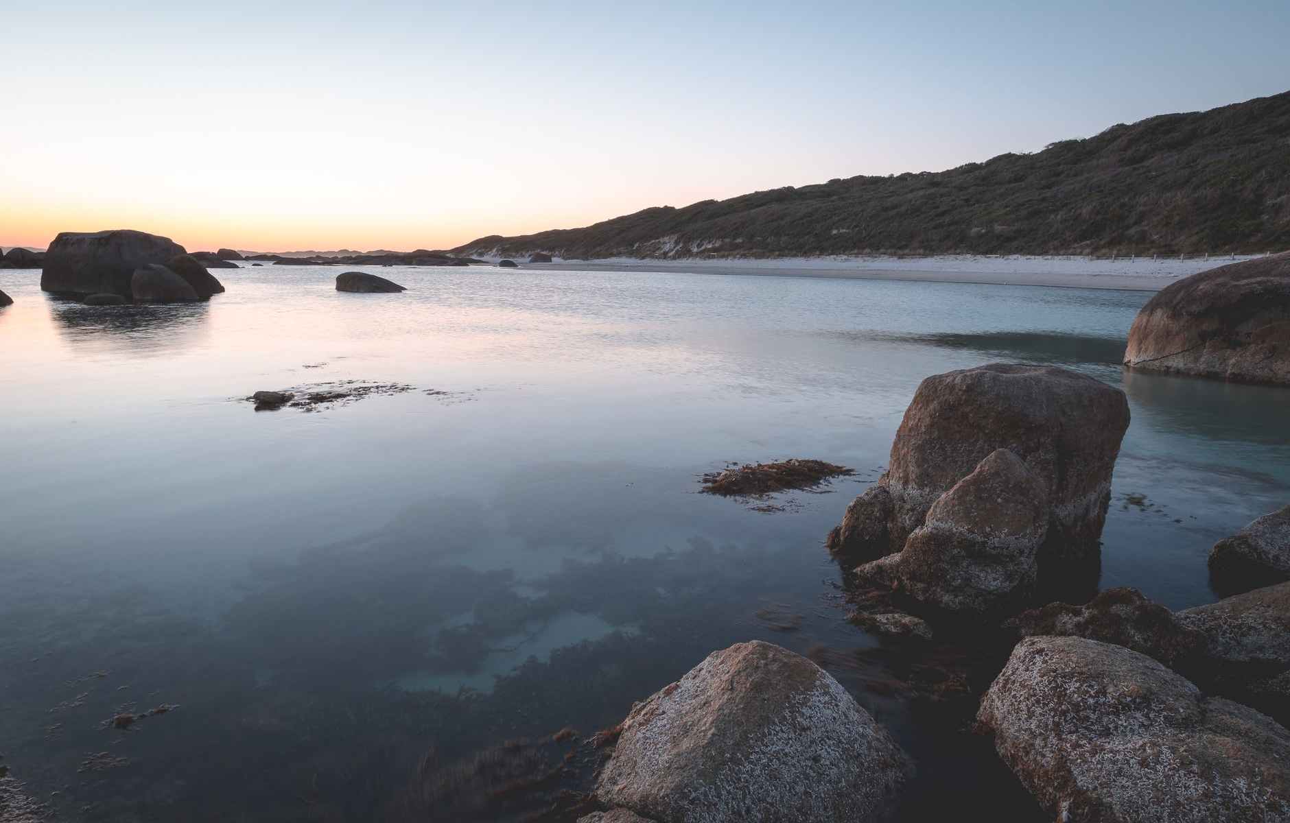 rocky seashore with calm seawater at twilight